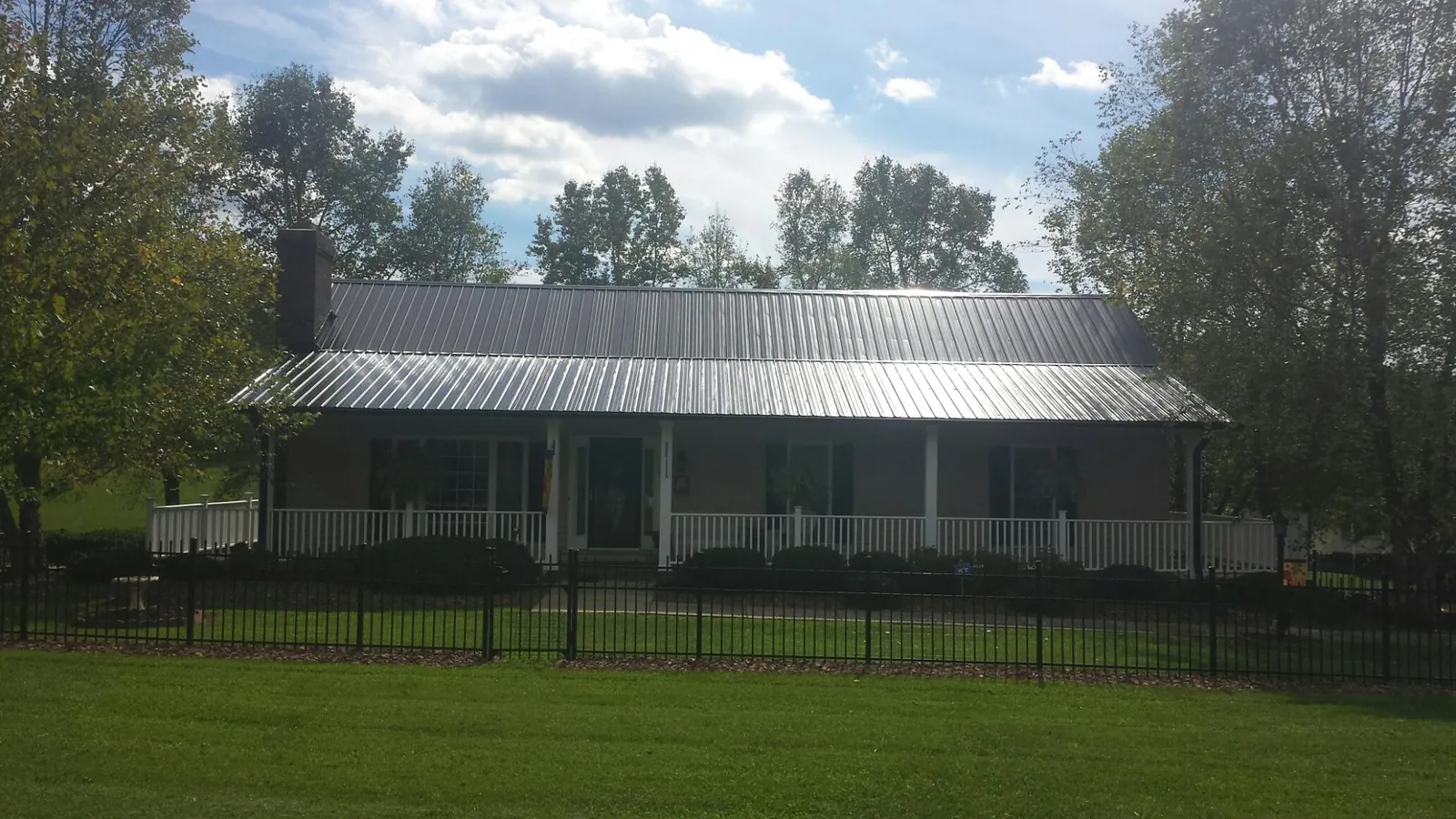 Gray metal roof on a brick ranch with a full width front porch — Gutter Guard Installation work by our crew in Sylmar